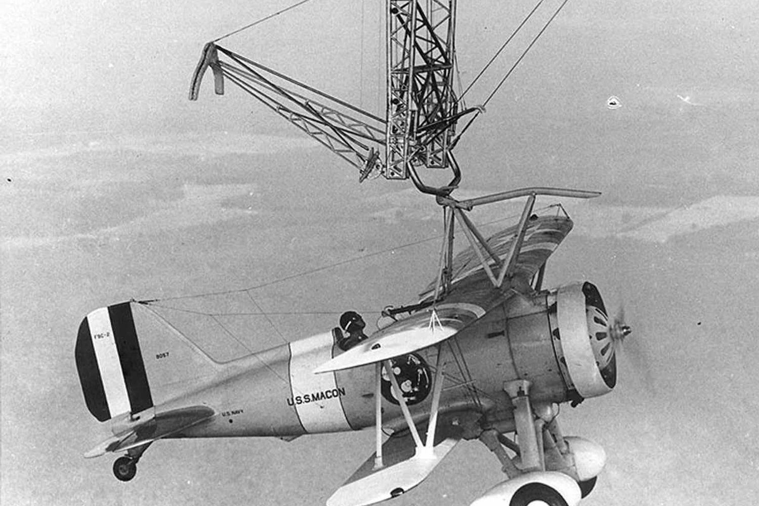 Olho no trapézio! Piloto completa o engate com o caça no USS Macon