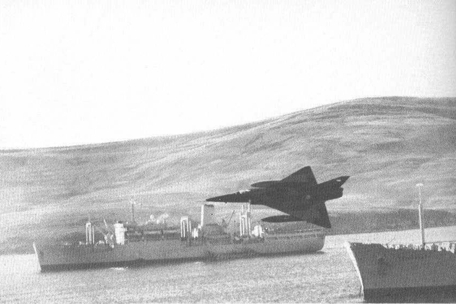 Dagger da FAA voando entre as embarcações britânicas, nas Malvinas (Domínio Público)