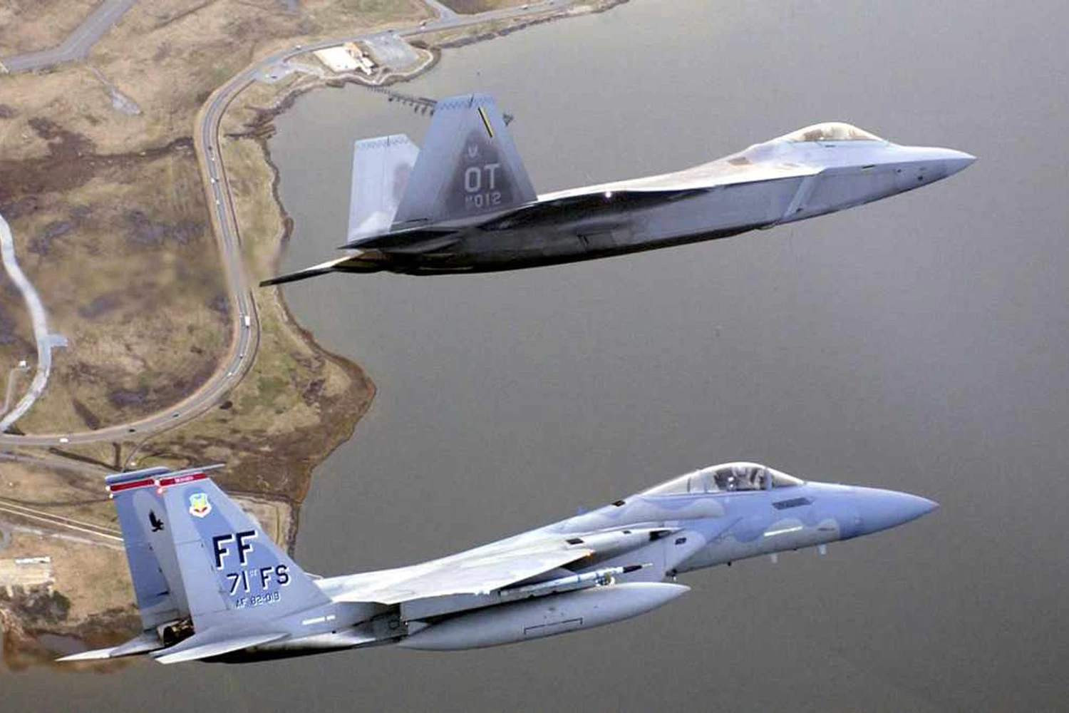 F-15C (monoposto) voando ao lado de um F-22 Raptor (USAF)