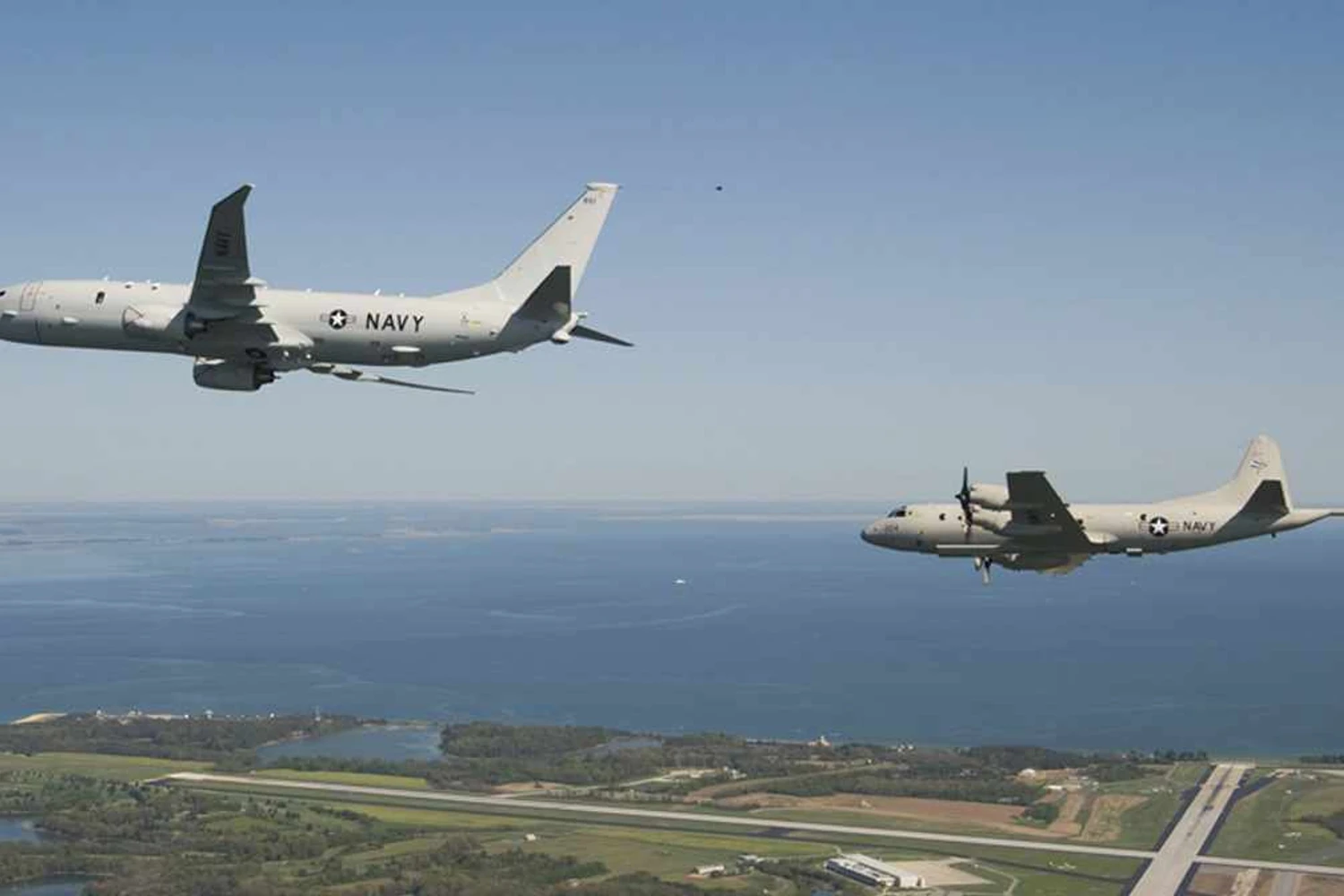 P-8A Poseidon voando em formação com um antigo P-3 Orion (US Navy)