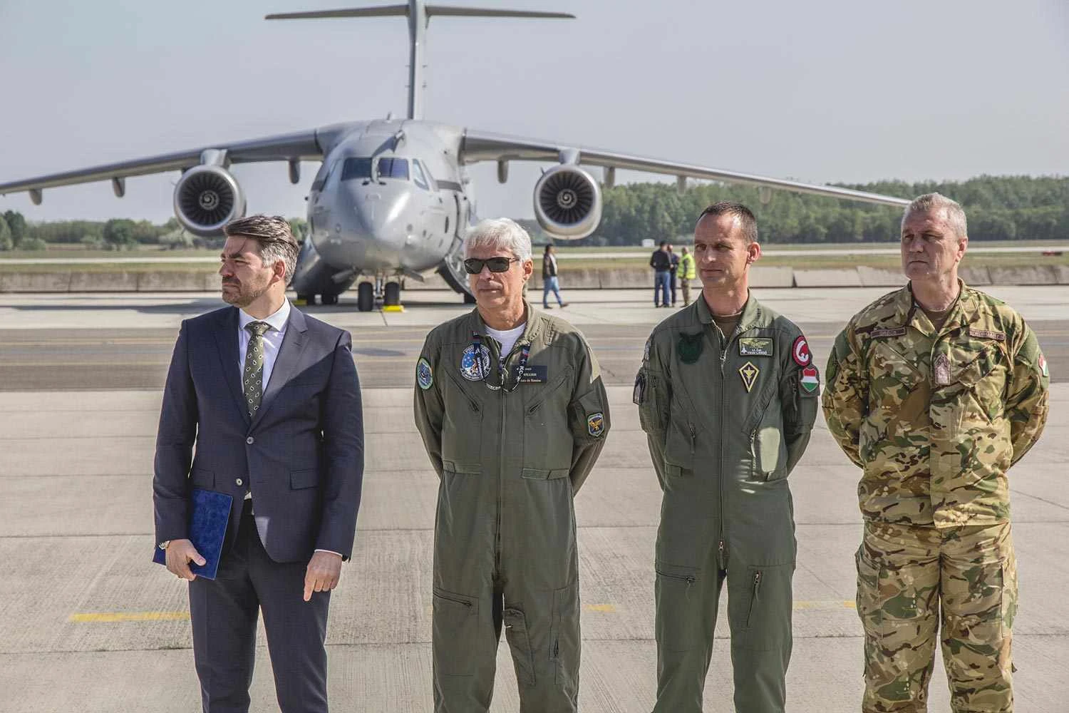 Zsolt Kutny&aacute;nszky, Secret&aacute;rio de Estado do Minist&eacute;rio da Defesa Nacional, William Souza, piloto de testes da Embraer, Major Viktor Lang&oacute;, Subcomandante Interino da Brigada, e Coronel Gy&ouml;rgy Gr&eacute;cs, Chefe do Estado-Maior
