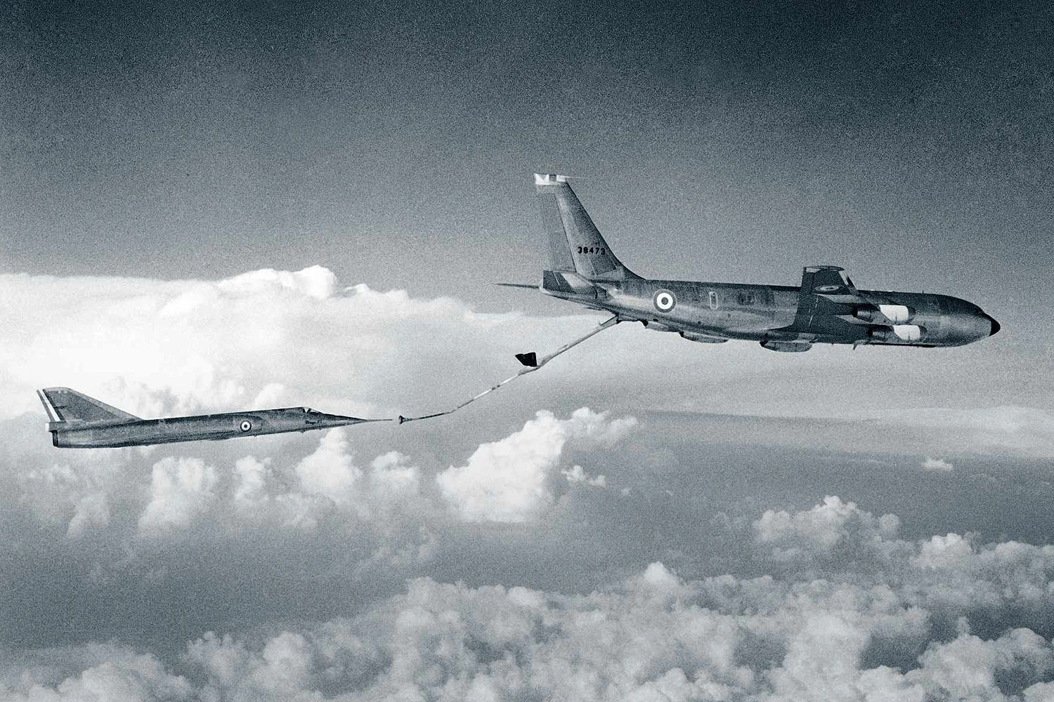 Um C-135F reabastece um Mirage IV utilizando a lança rígida com kit de mangueira/drogue adaptado (FAF)