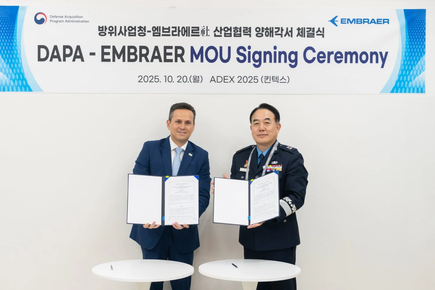 Representantes da Embraer e da DAPA assinam o memorando (Embraer)