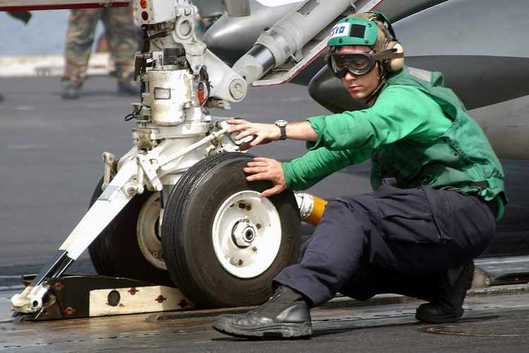 Trem de pouso dianteiro de um caça F-18 preso a catapulta de lançamento (US Navy)