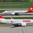 Um Airbus A220-100 da Swiss e ao fundo o E190-E2 da Helvetic